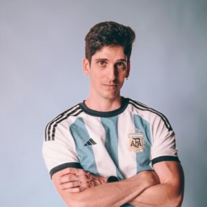 Young man in an Argentina soccer jersey poses confidently against a neutral background.